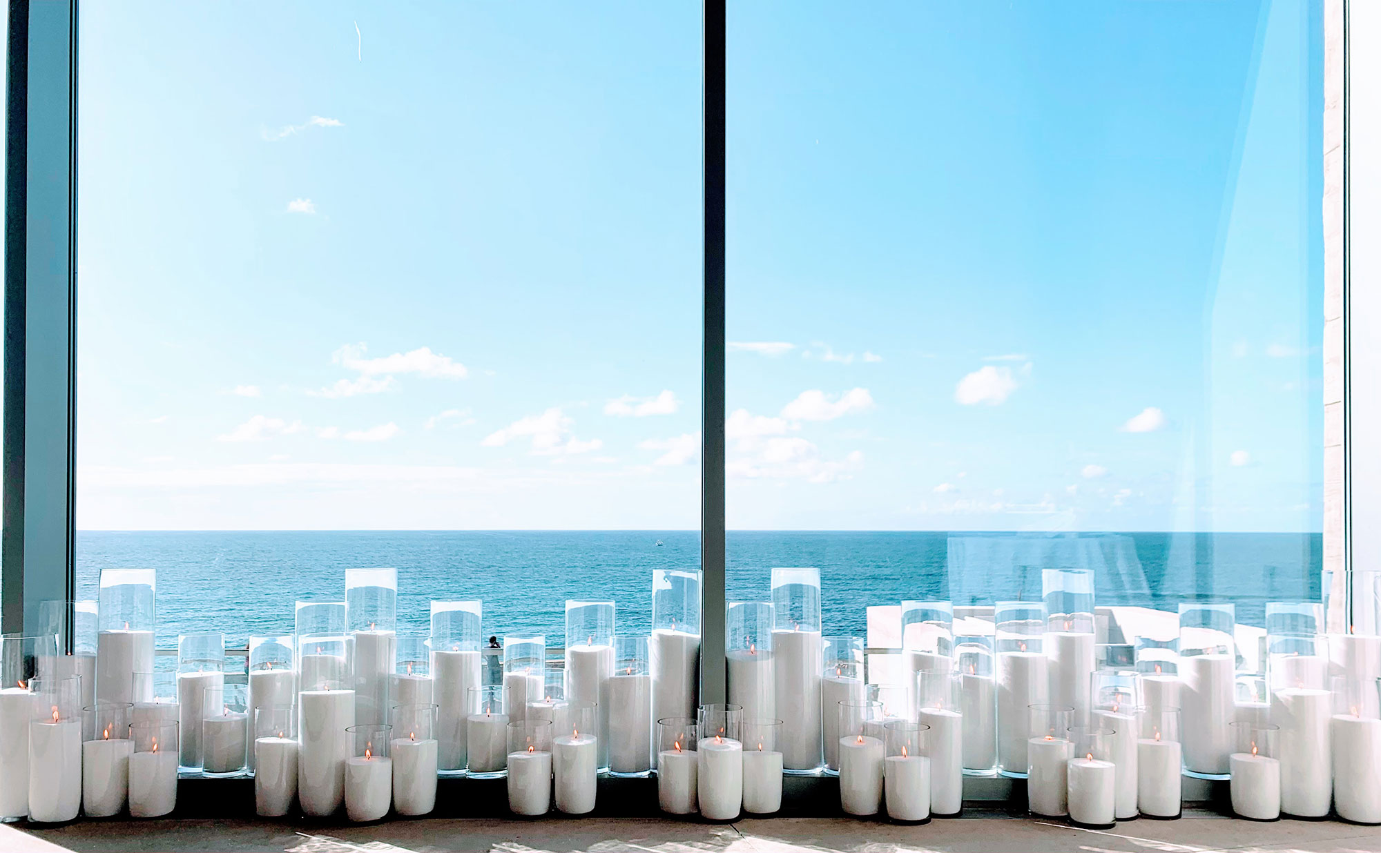 candles set up near window looking over the ocean