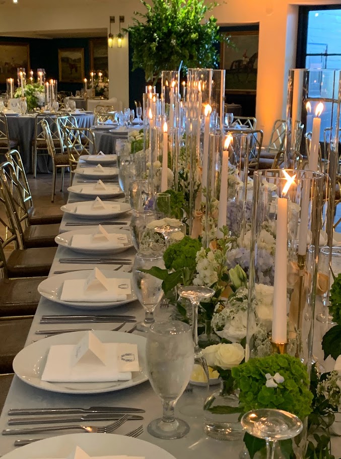 Taper Candles with bows on Long Table with small greenery and gold bases