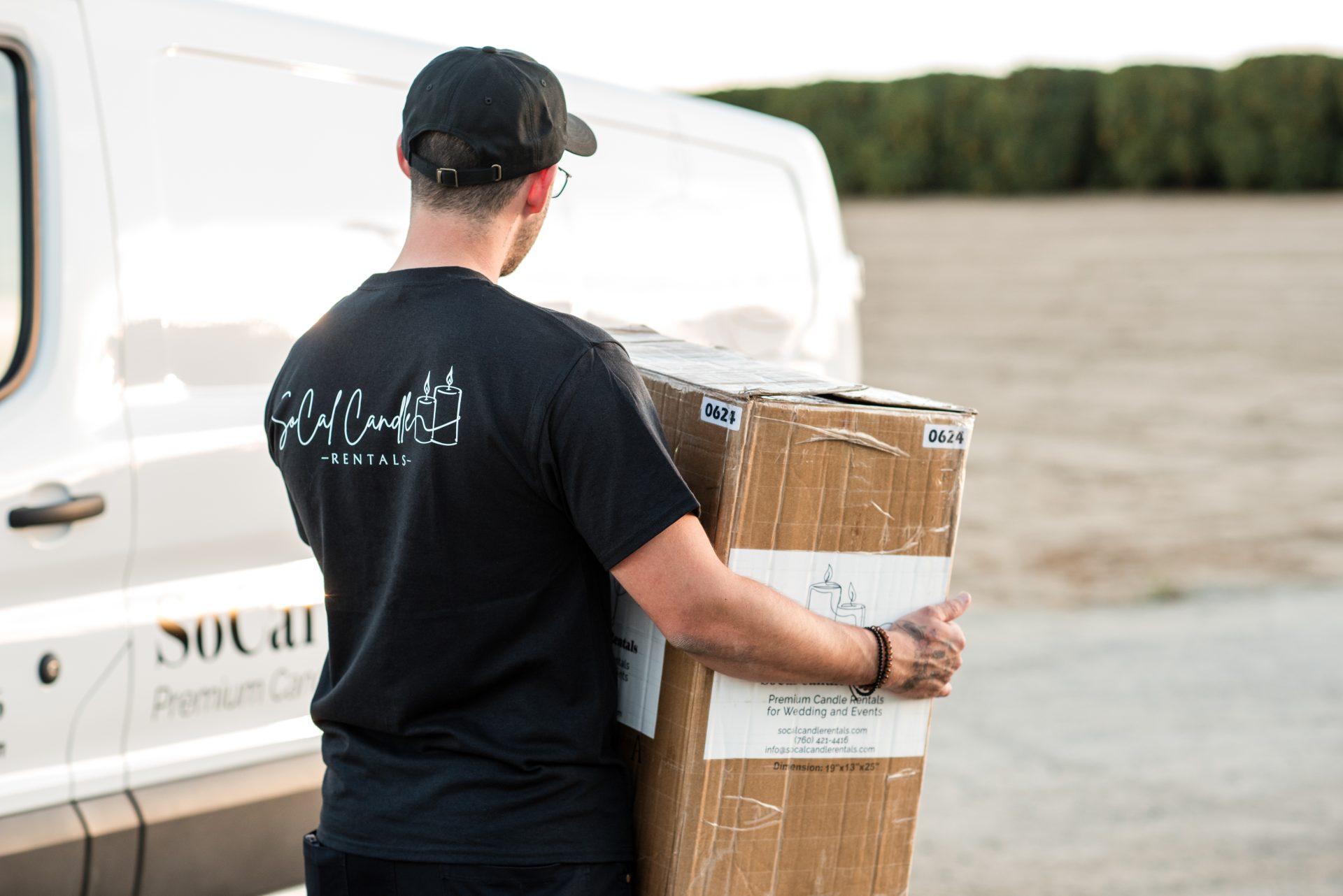 socal candles rentals employee carrying a box of candles